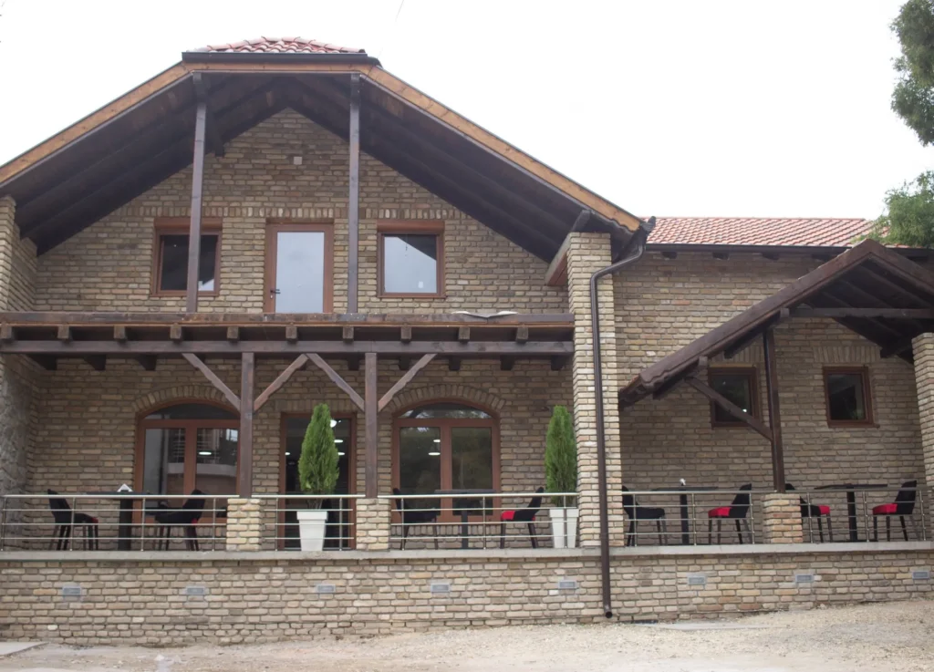 Duga aluminijumska ograda na terasi kuće od fasadne cigle